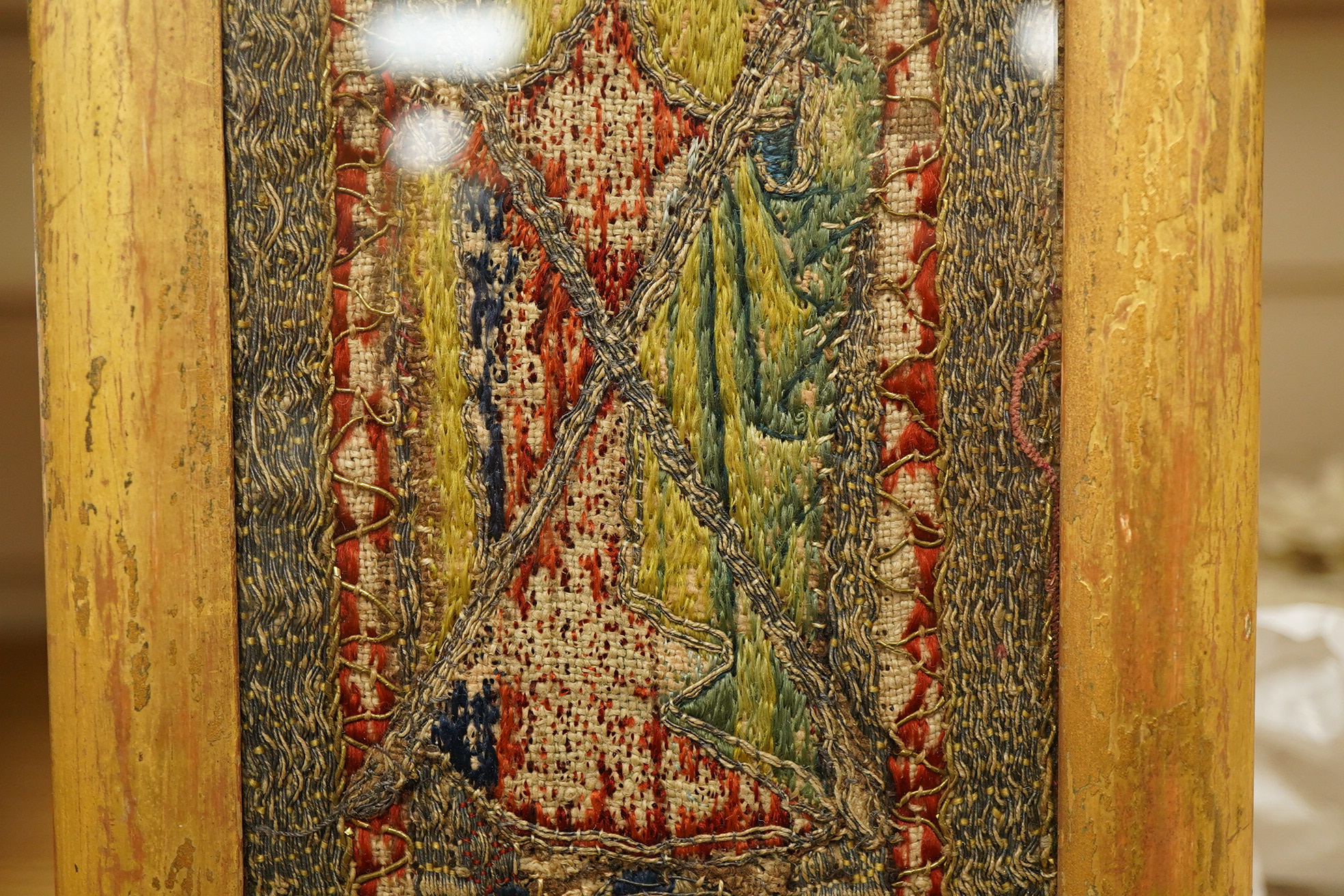 An early 16th century ‘Opus Anglicanum’ (English work), silk and metal thread embroidered fragment, of Saint Andrew, possibly cut from an orphrey, later framed and glazed, 28.5cm high x 9.5cm wide. Condition - the silk t